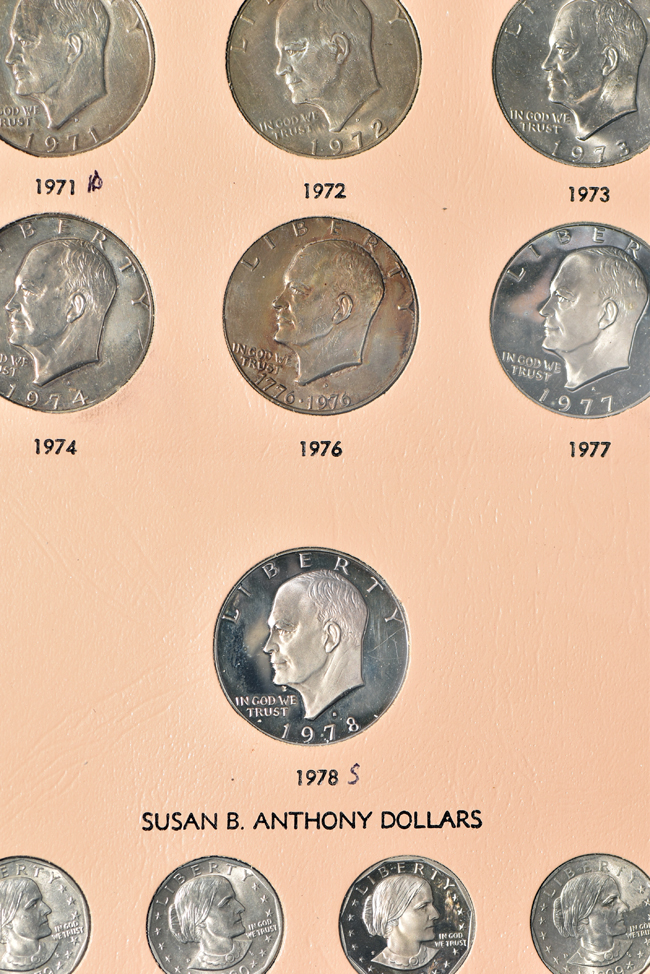 Collection of Morgan, Peace, Eisenhower, and Susan B. Anthony dollars in a Dansco album