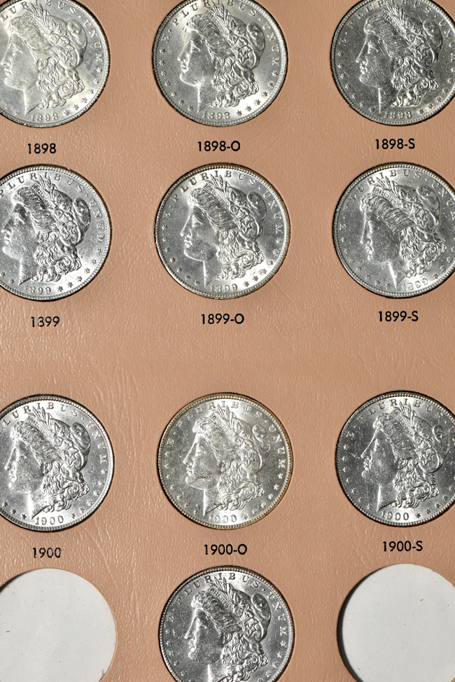 Collection of thirty-three different Morgan silver dollars in a Dansco 7179 album