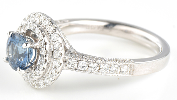 There is a 1.00 ct. round sapphire, with heated treatment, in the center of this double halo ring that contains .76 cttw in brilliant cut round side diamonds, SI1 clarity, G color. Ring size 6, 3.4 dw