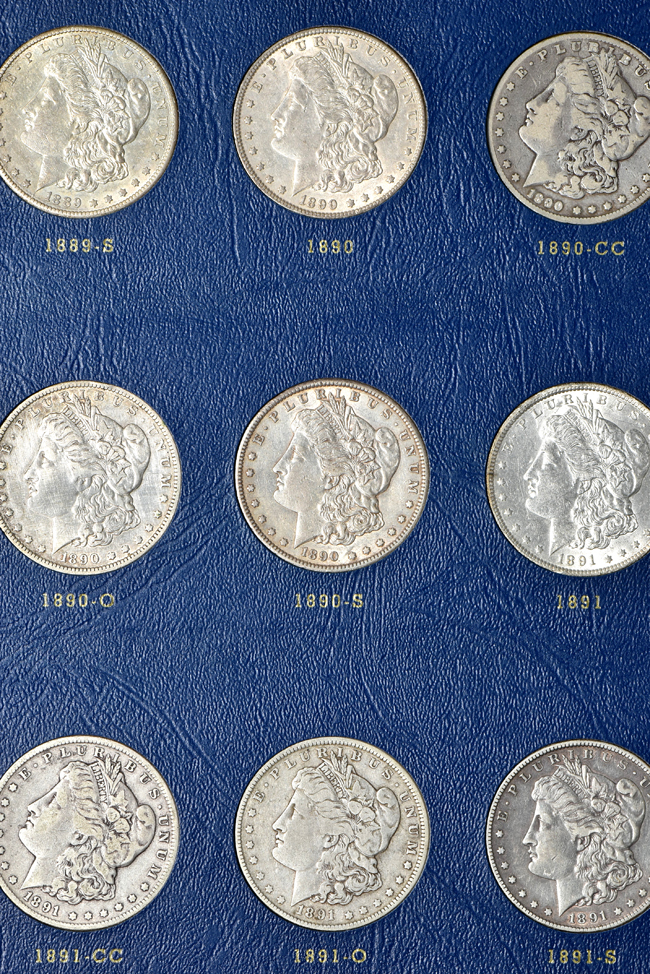 Group of thirty-three different Morgan silver dollars in a Whitman 9428 album