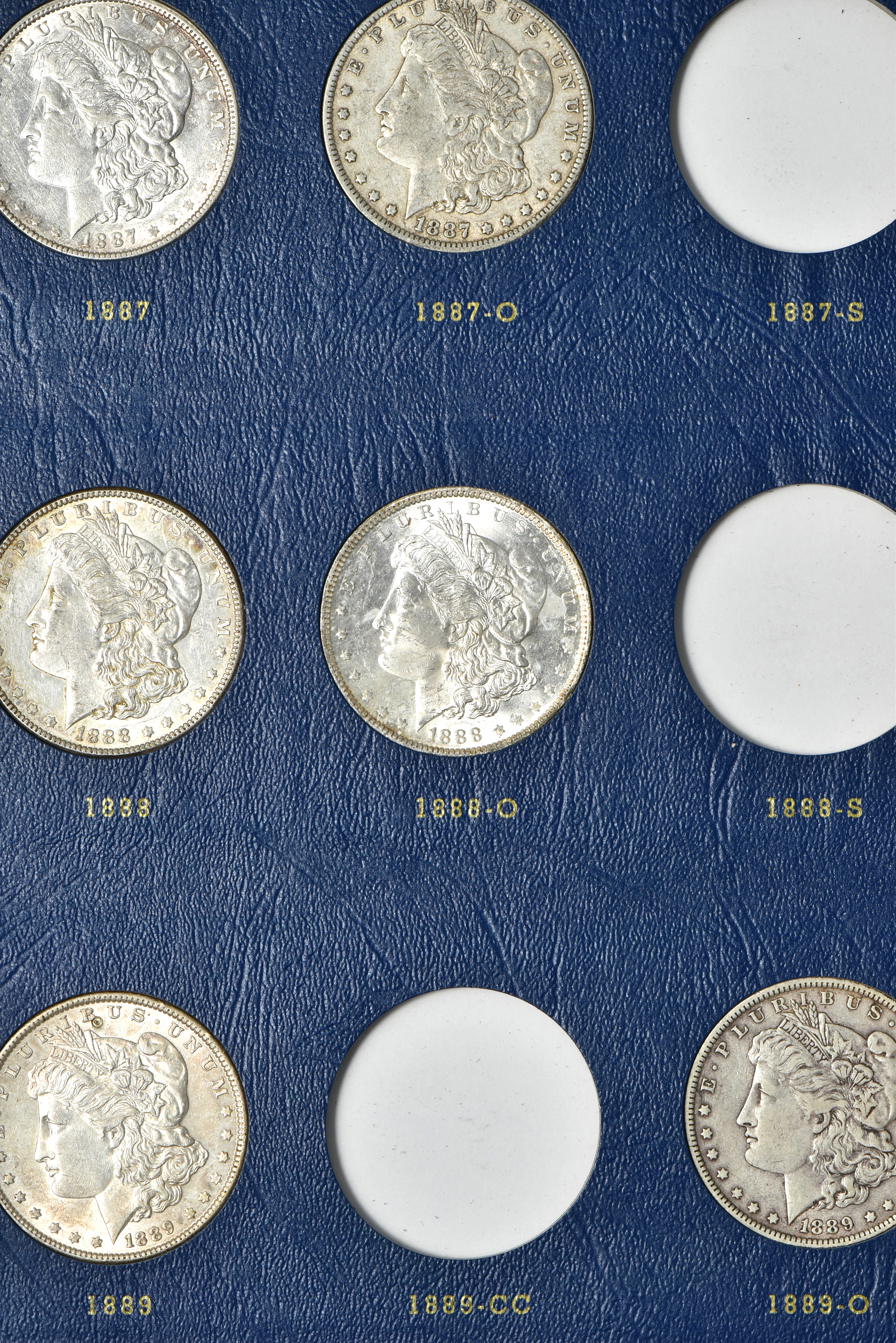 Collection of 73 different Morgan silver dollars in three Whitman albums