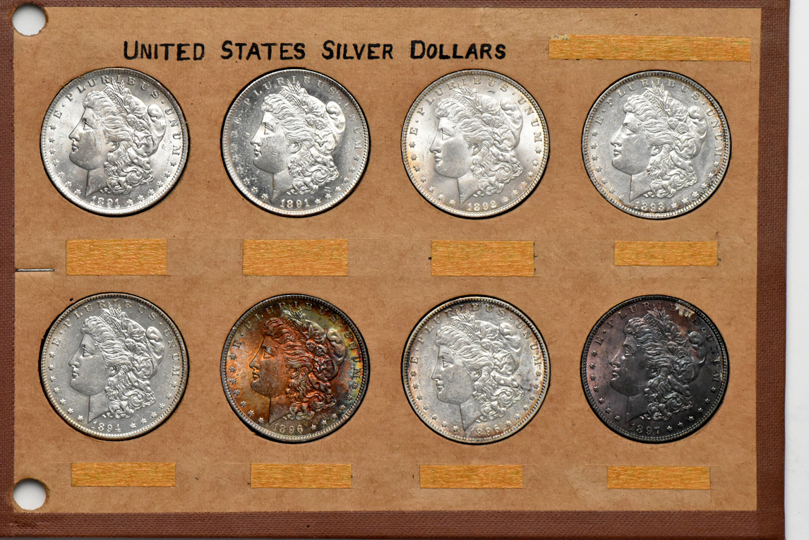 Collection of 32 different Morgan silver dollars in a Wayte Raymond album