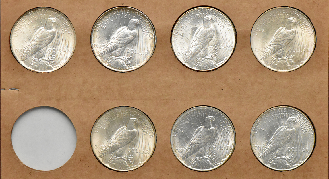 Collection of Peace silver dollars in a The National Coin album