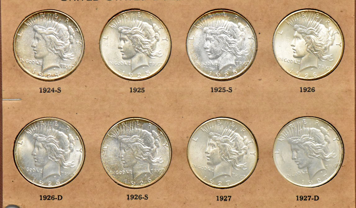 Collection of Peace silver dollars in a The National Coin album