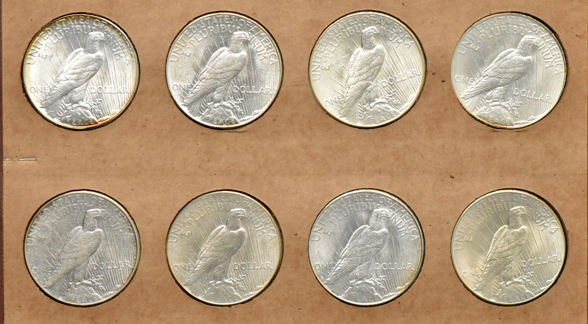 Collection of Peace silver dollars in a The National Coin album