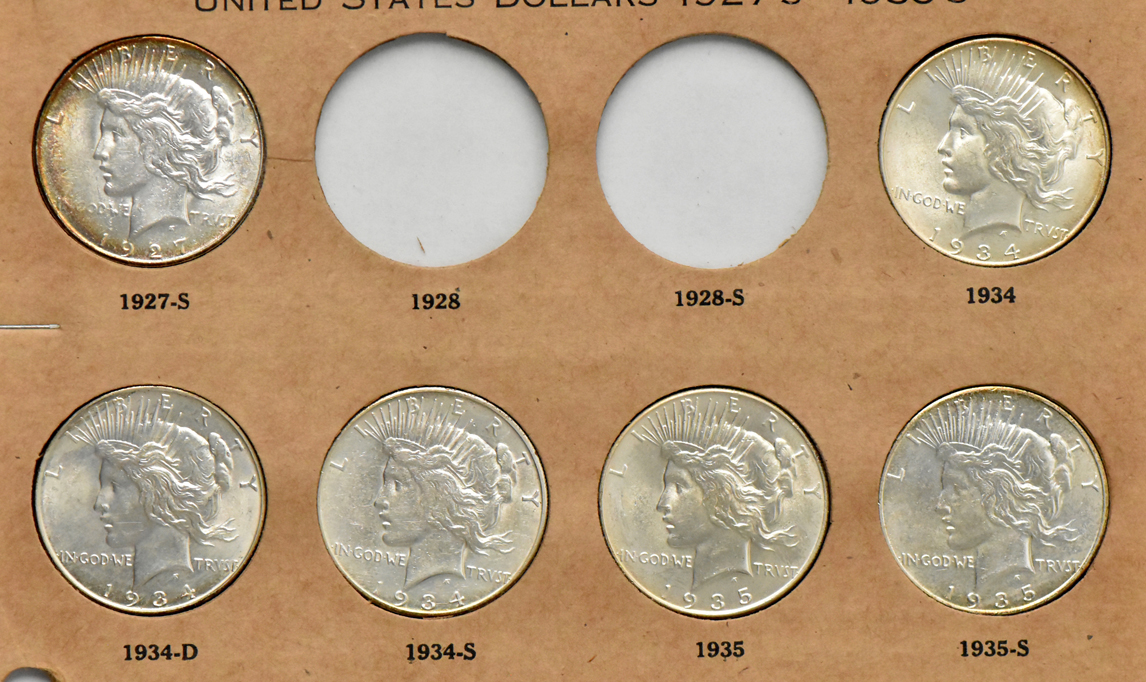 Collection of Peace silver dollars in a The National Coin album