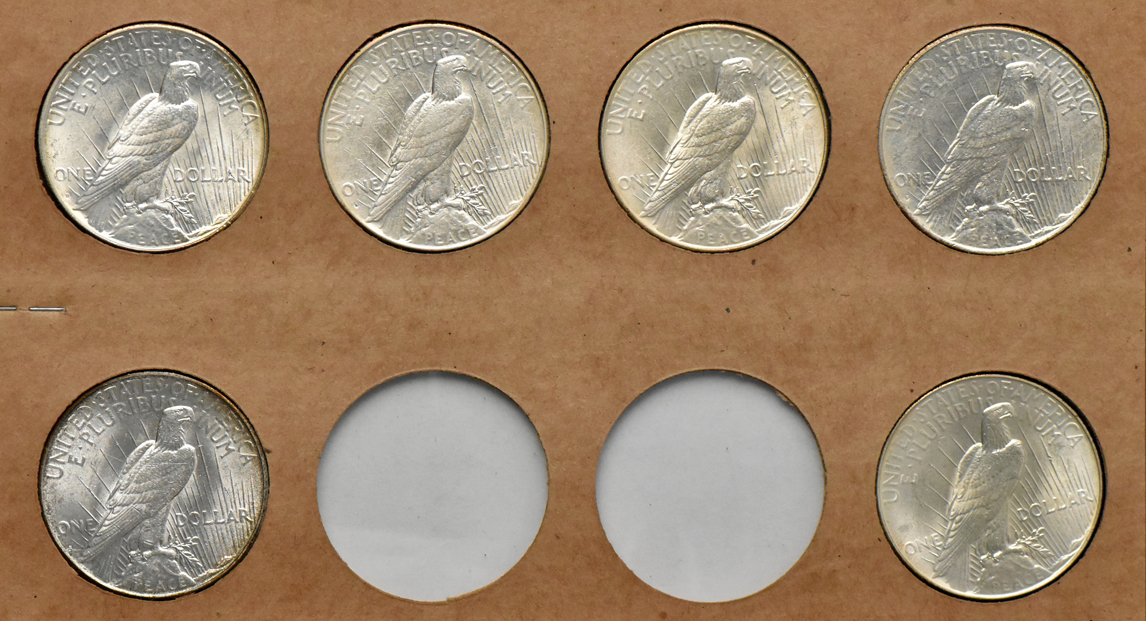 Collection of Peace silver dollars in a The National Coin album