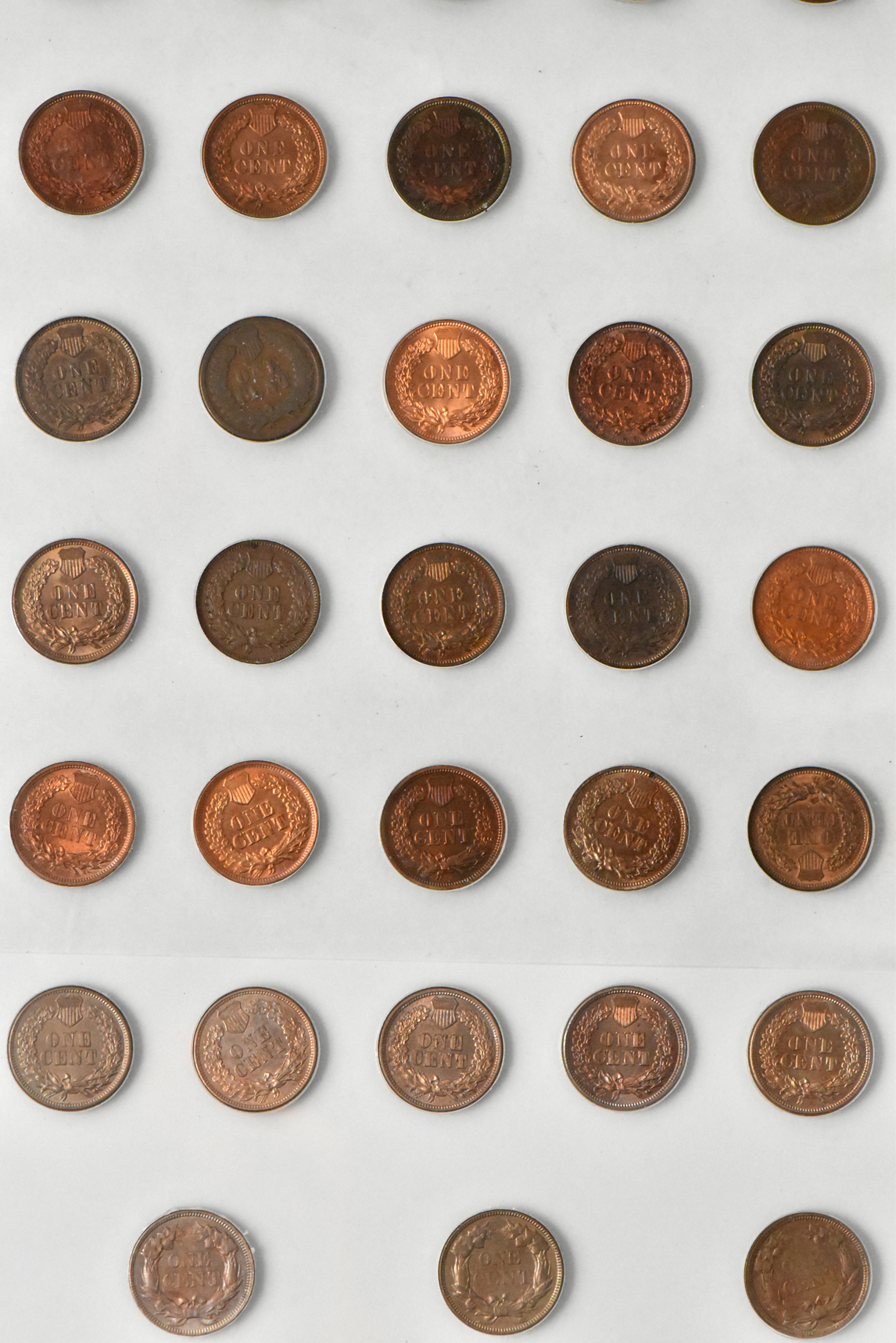 Three Flying Eagle cents and 55 Indian cents in a Capital Plastics like holder