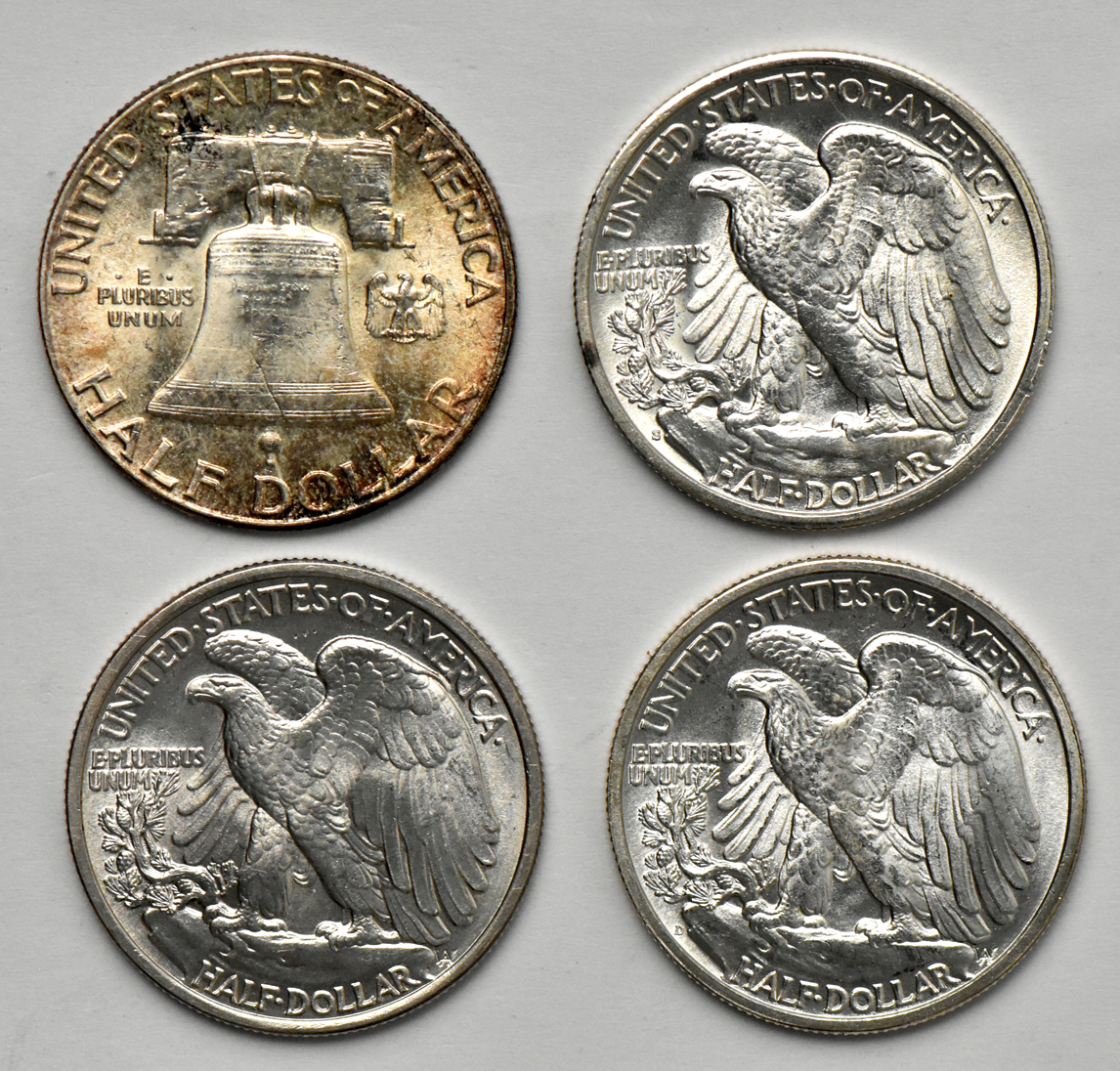 Three Walking Liberty half dollars and one Franklin half dollar, all BU.