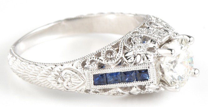 14K White Gold Diamond Engagement Ring with a 1.01 Carat Round Cut Diamond, SI1 Clarity, H Color, GIA # 2171882372 with .35 Carat Total Weight in Sapphires and .06 Carat Total Weight in Diamonds.
