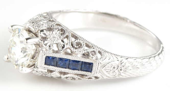14K White Gold Diamond Engagement Ring with a 1.01 Carat Round Cut Diamond, SI1 Clarity, H Color, GIA # 2171882372 with .35 Carat Total Weight in Sapphires and .06 Carat Total Weight in Diamonds.