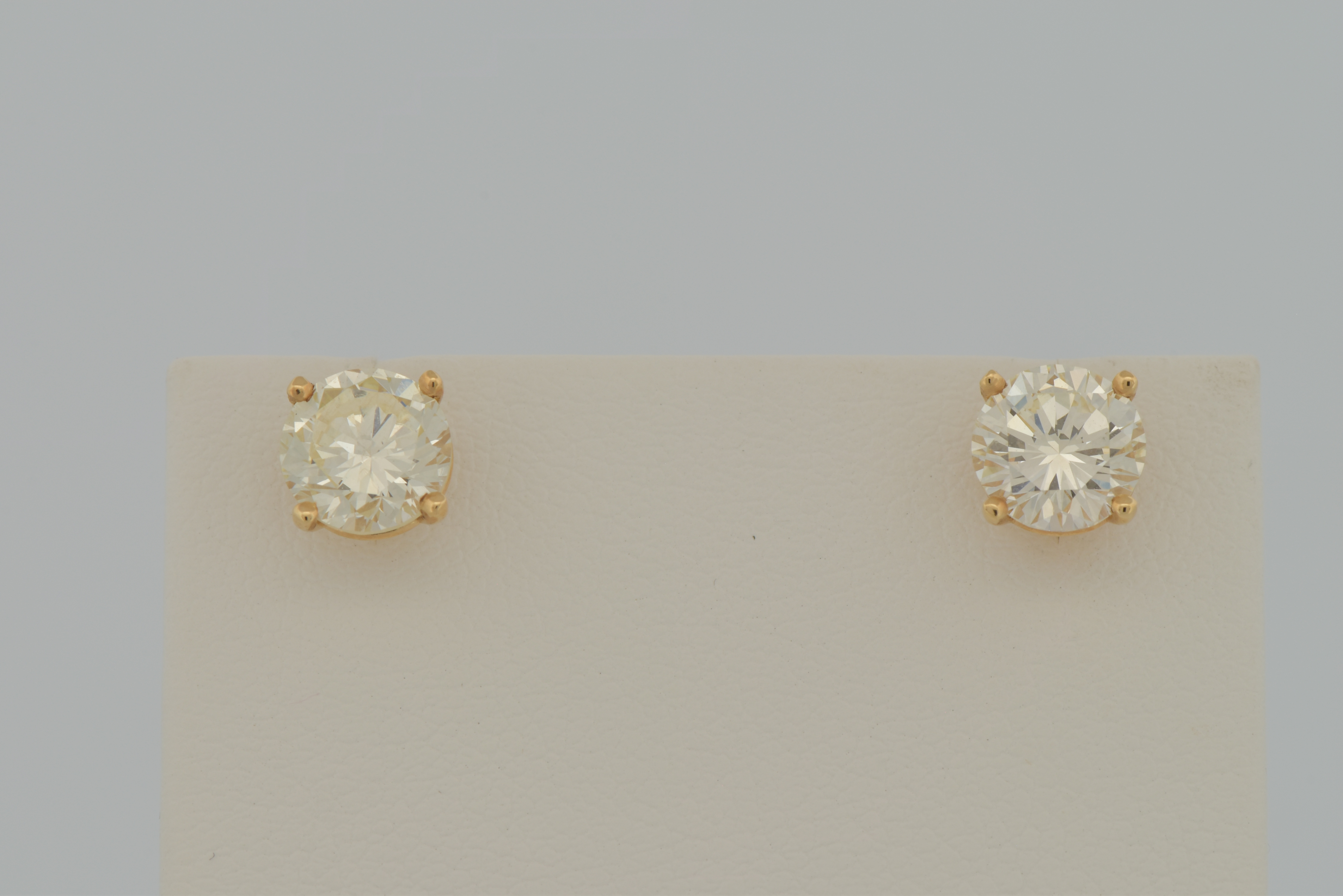 14K Yellow Gold Diamond Stud Earrings with a 1.01 Carat Round Cut Diamond, VS1 Clarity, M Color, GIA # 6224345966 and a 1.06 Carat Round Cut Diamond, VS2 Clarity, N Color, GIA # 2211727759.